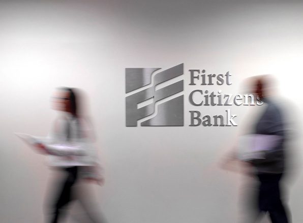 First Citizens Bank logo with blurry people in an office